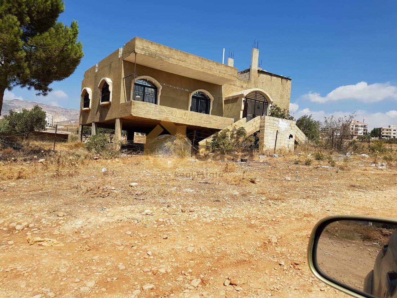 land for sale in zahle with shops and apartment on it .